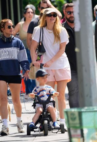 Jennifer Lawerence wears Freja mini chrystie bag in black with a white t-shirt, and pink shorts.