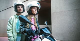 A young couple riding the Piaggio 1 e-scooter