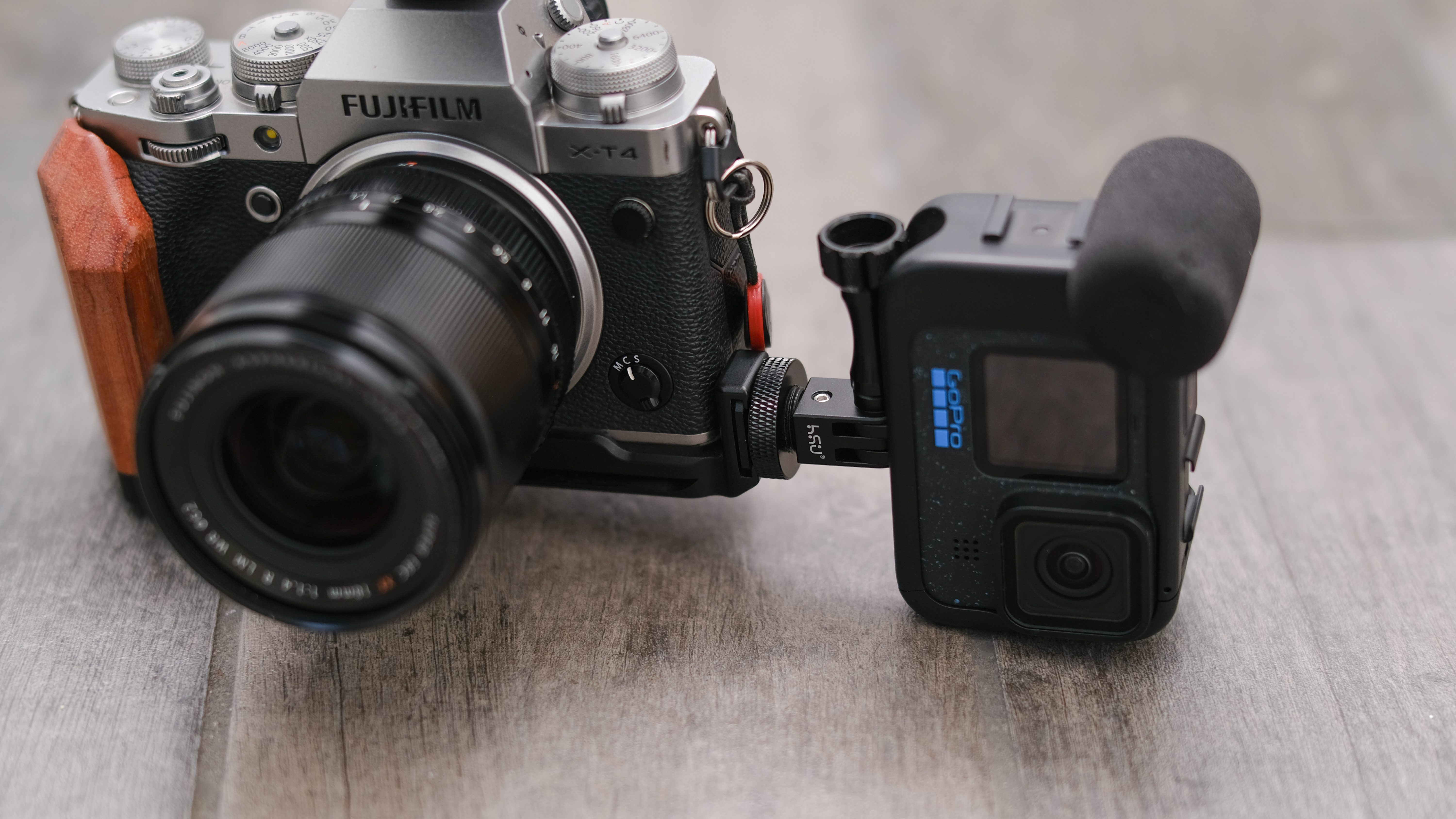 A GoPro sits mounted sidewise on a Fujifilm X-T4
