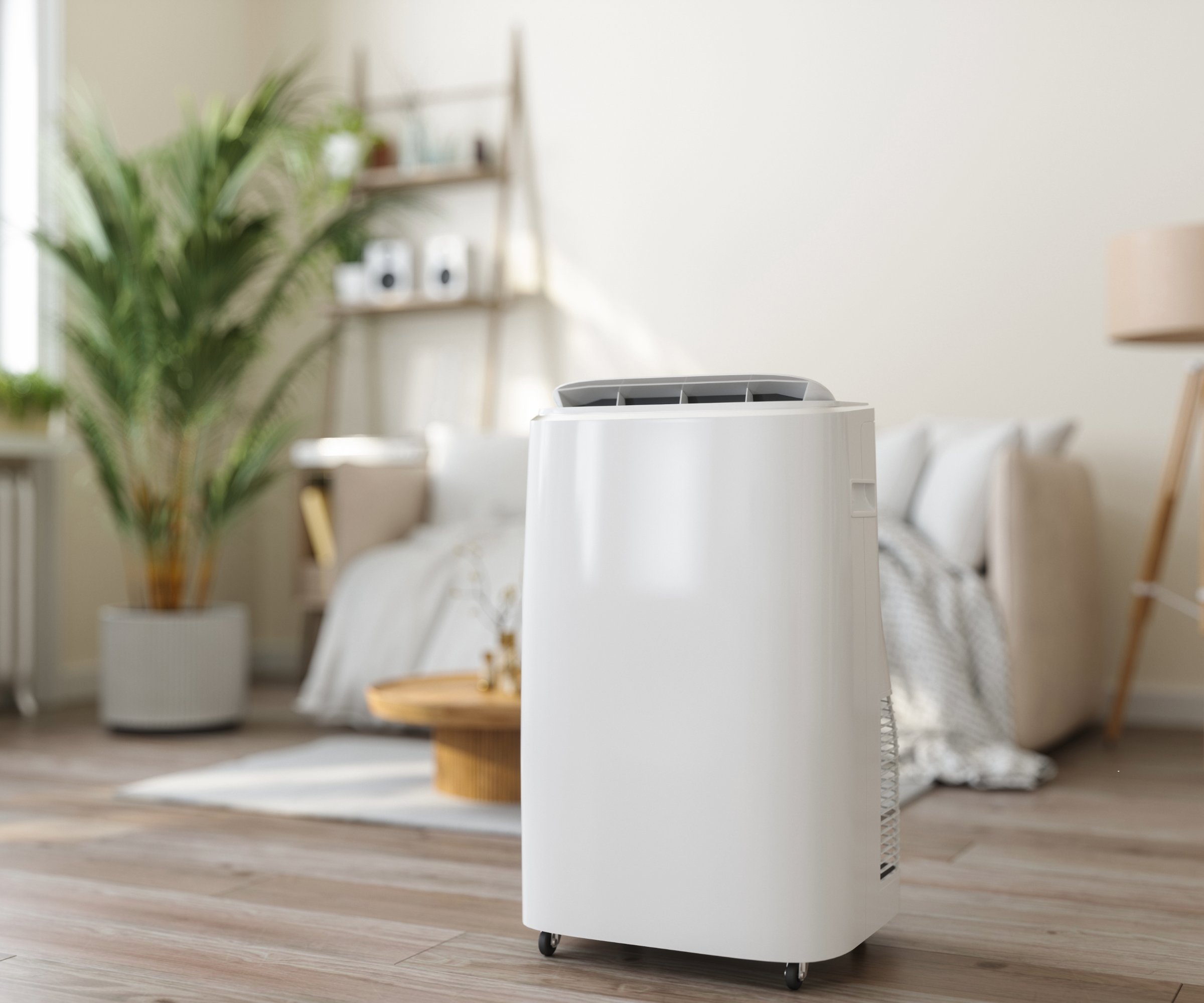 Dehumidifier placed on wooden flooring in front of a plant and couch in a living room
