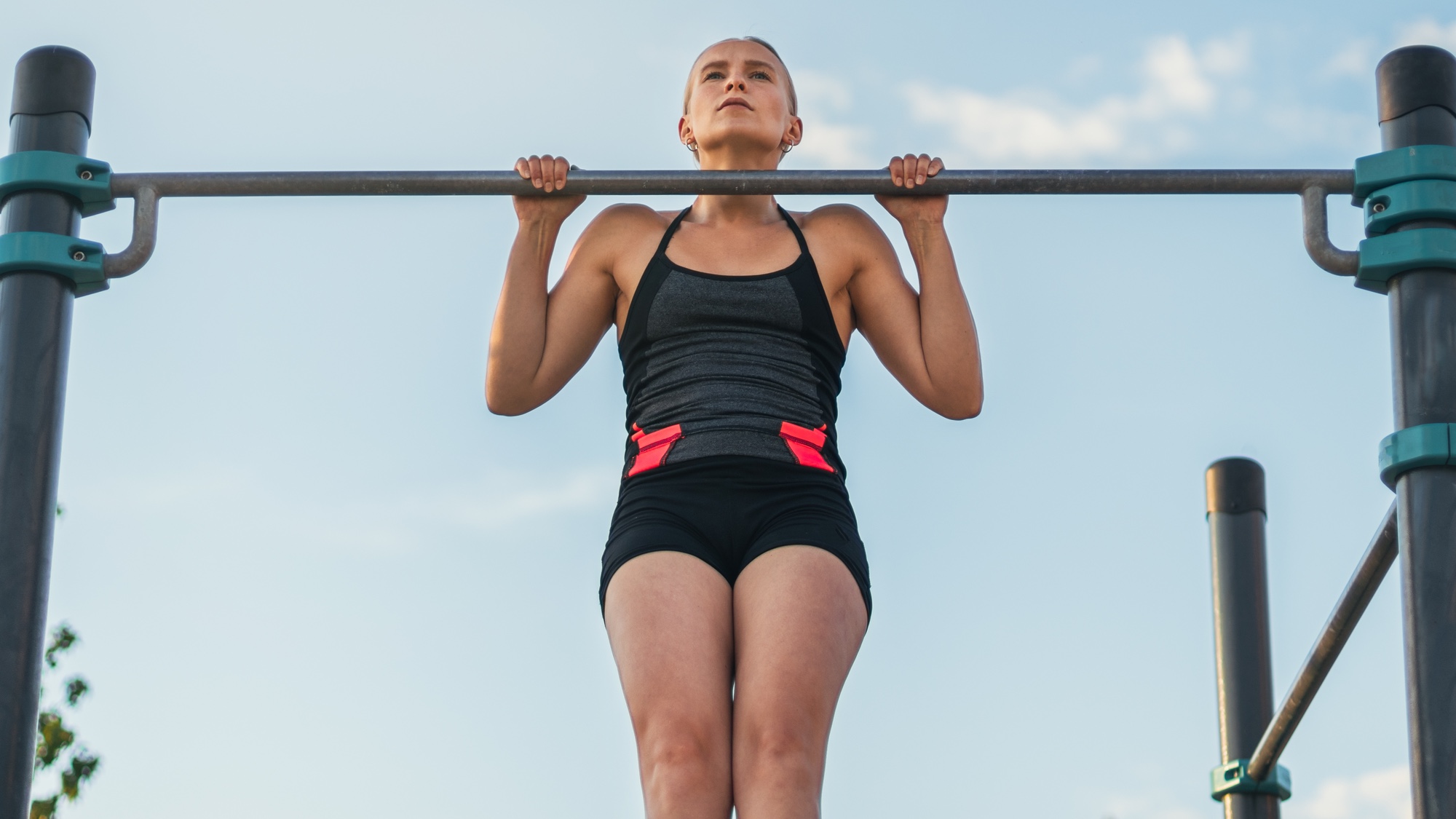 Woman doing pull-ups outside