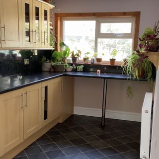 Dated kitchen with oak cabinets and black lino flooring.