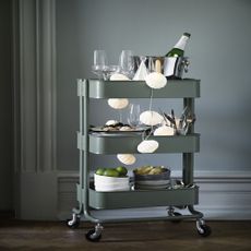 Green RÅSKOG trolley being used as a bar cart