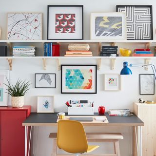 room with white wall and floating book shelf wooden desk and yellow chair