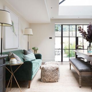 open plan kitchen with roof lantern and green velvet sofa