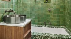 green zellige tiles in a bathroom with terrazzo and a chrome sink