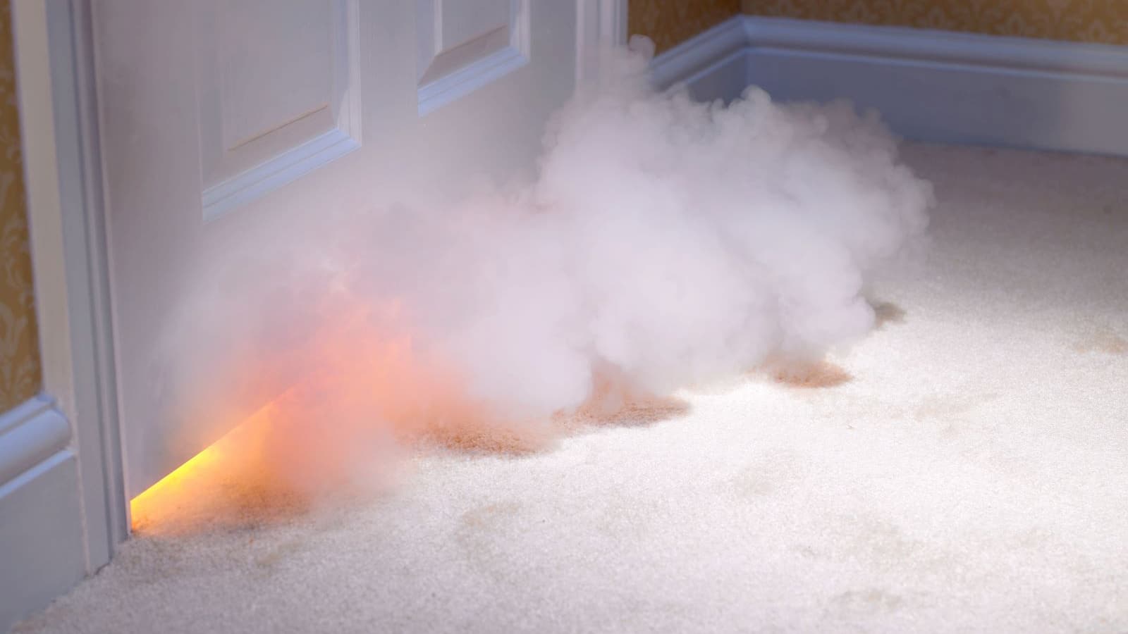 A door hiding a fire inside a room with smoke coming out