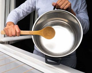 using pan and spoon to make noise to scare away pests