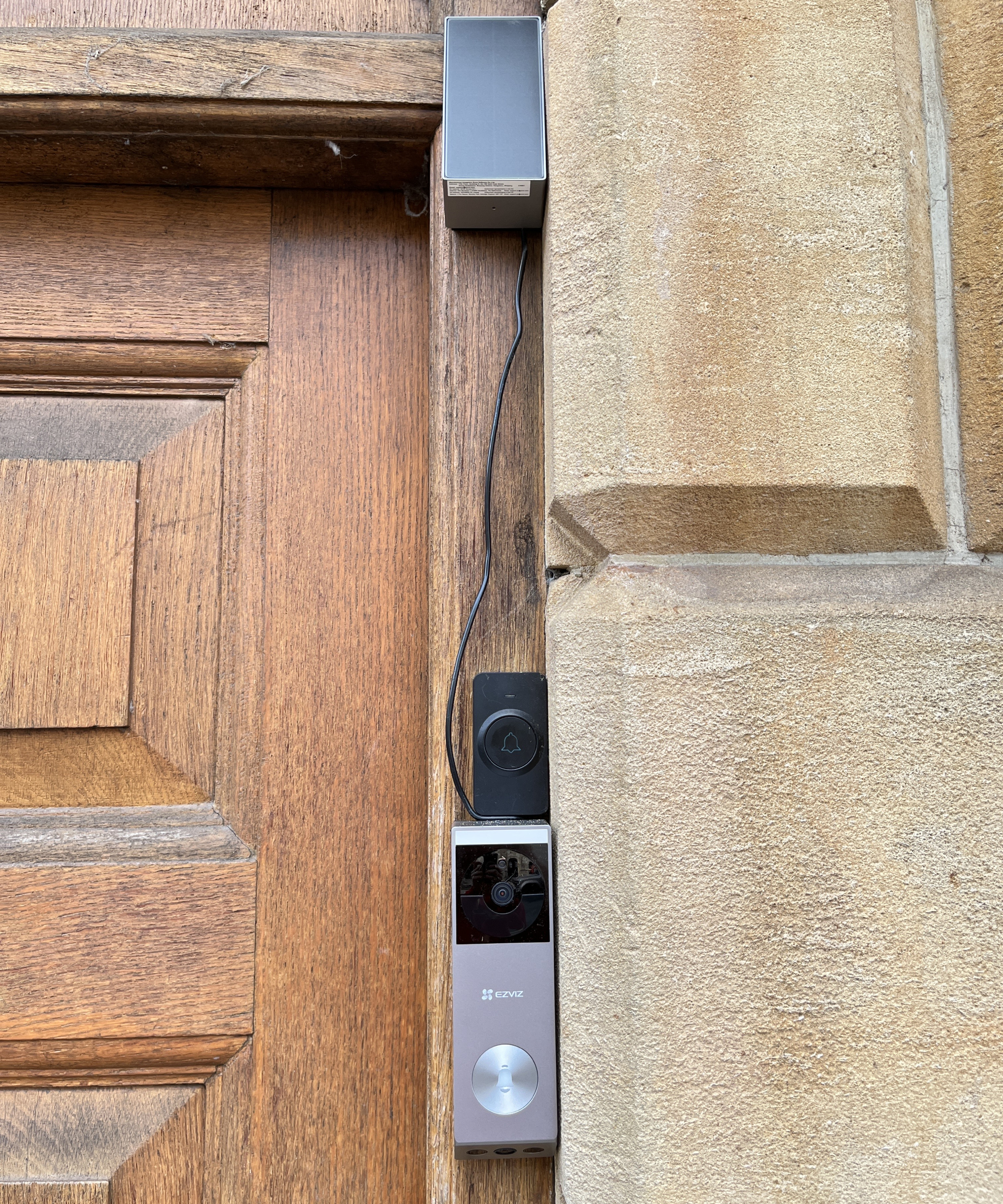 Ezviz video doorbell and solar panel installed on wooden door frame