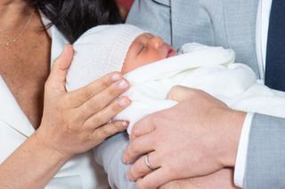 HRH Prince Harry, Duke of Sussex, and his wife Meghan, Duchess of Sussex, pose for a photo with their newborn baby son in St George's Hall at Windsor Castle on May 8, 2019. (Photo by Dominic Lipinski / AFP /Getty Images)