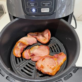 Cooked bacon in the basket of the Ninja AF100UK Air Fryer