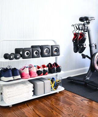 a neatly organized small home gym with many pairs of trainers
