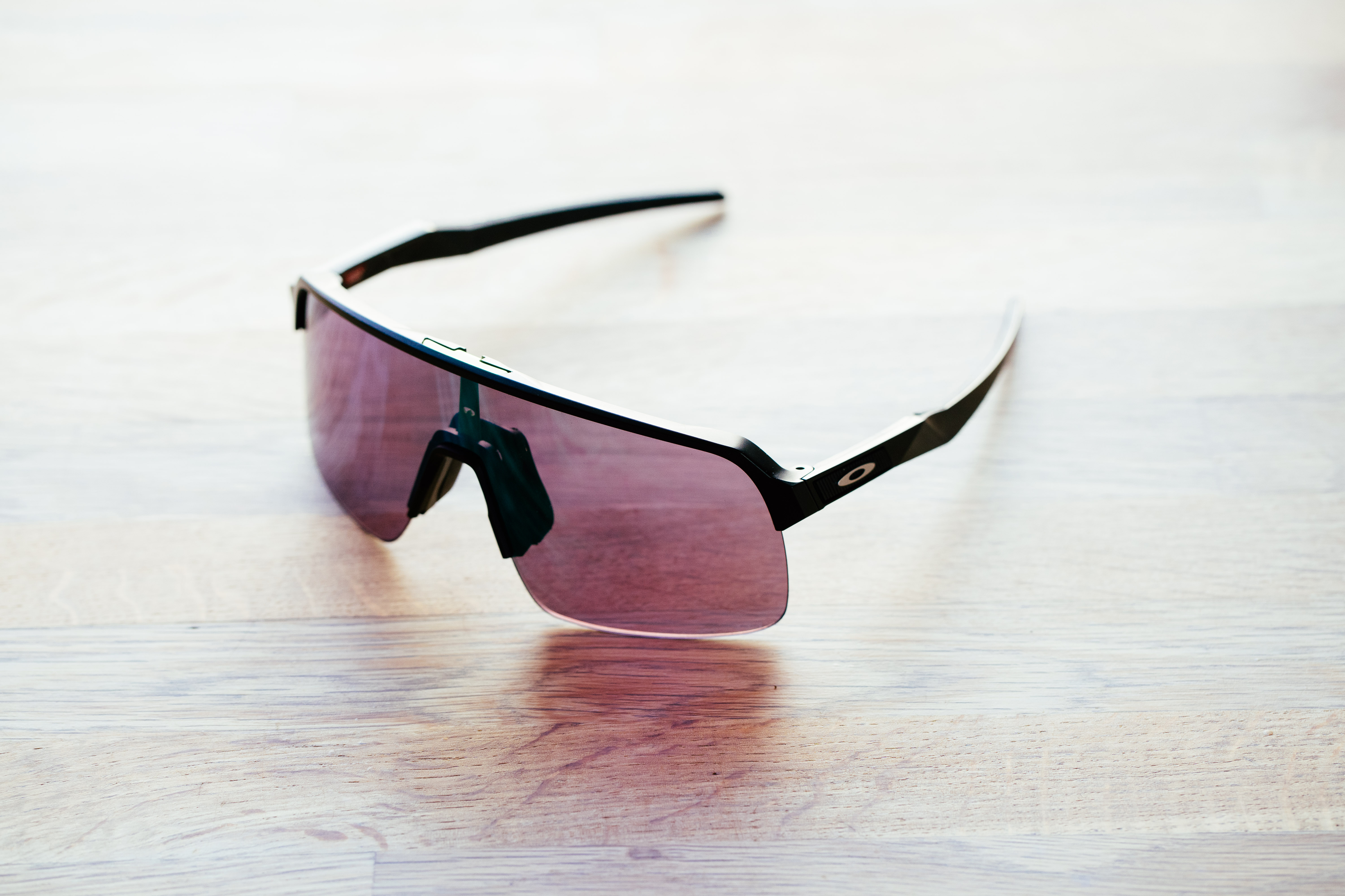 A set of half-frame cycling glasses on a wooden surface