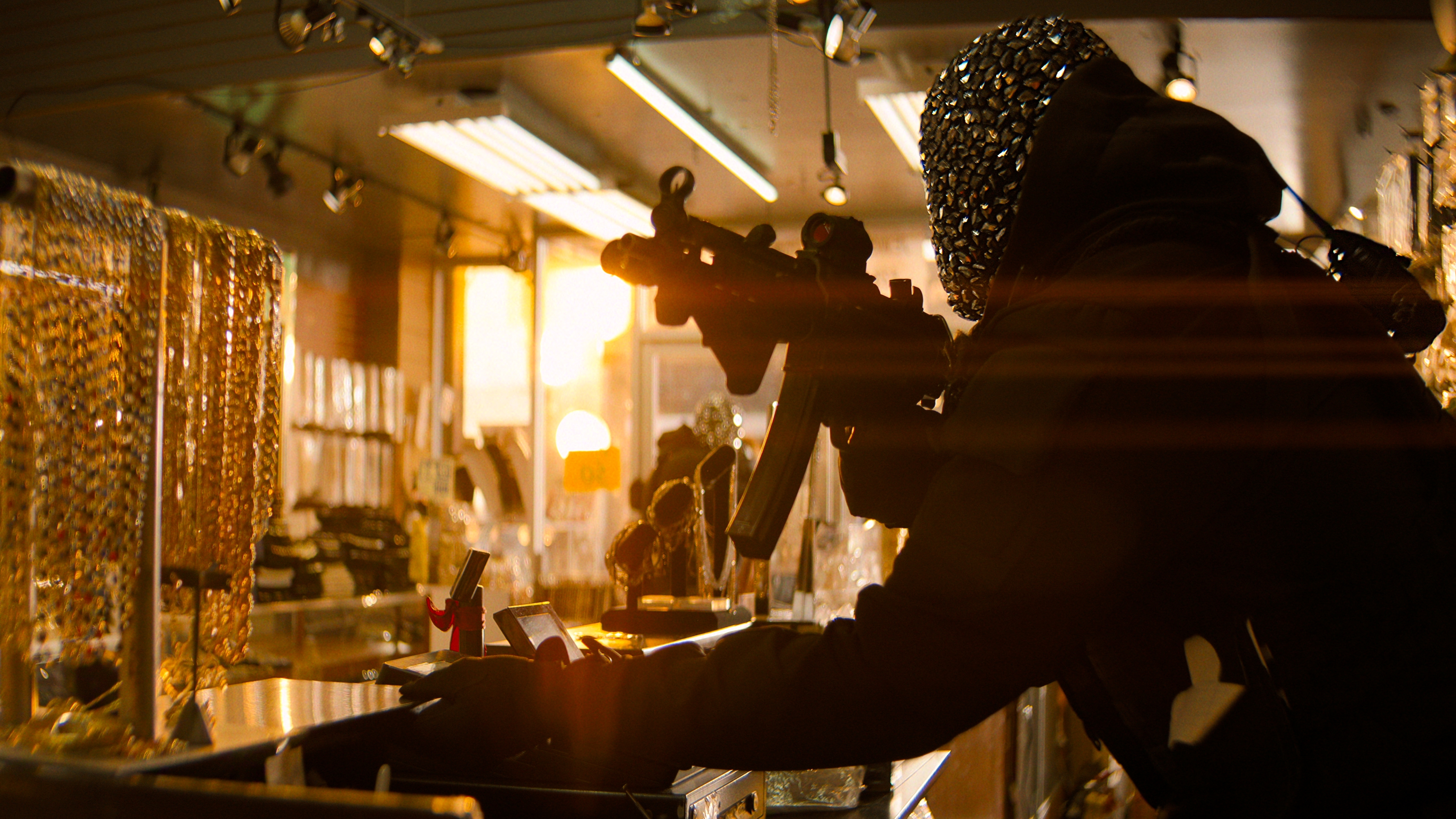 A masked person holding a gun in a scene from "Nemesis"