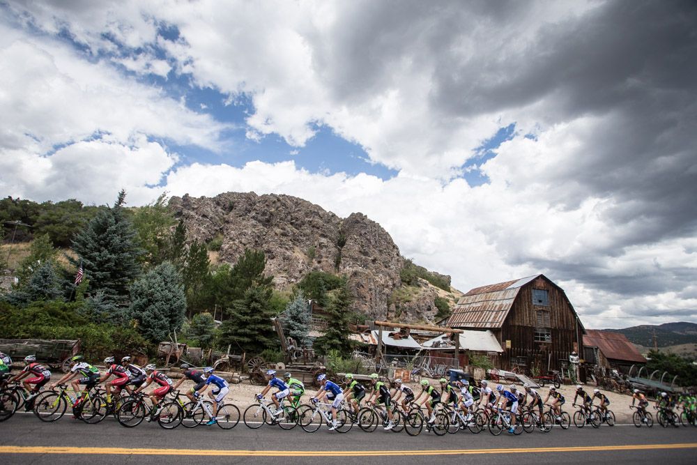 The peloton heads past an old farm collection.