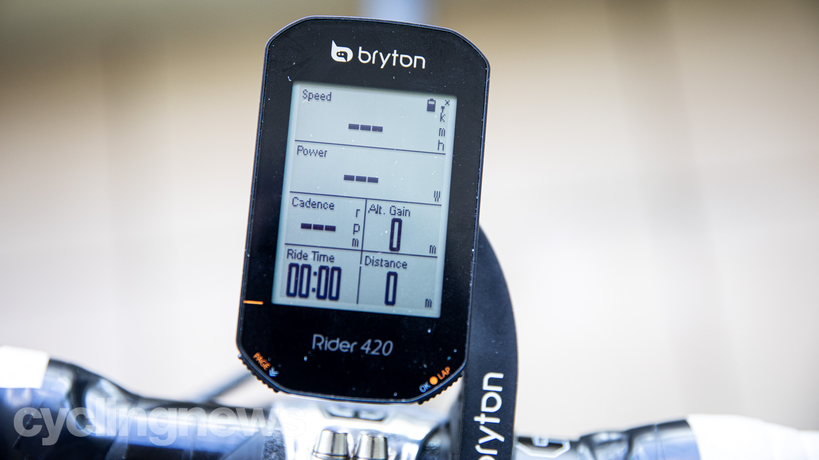 Bryton Rider 440 smart computer mounted to a set of handlebars, with speed, power, cadence, altitude gain, ride time, and distance on the black and white screen