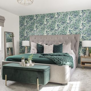 bedroom with green designed wall and grey bed with designed cushions