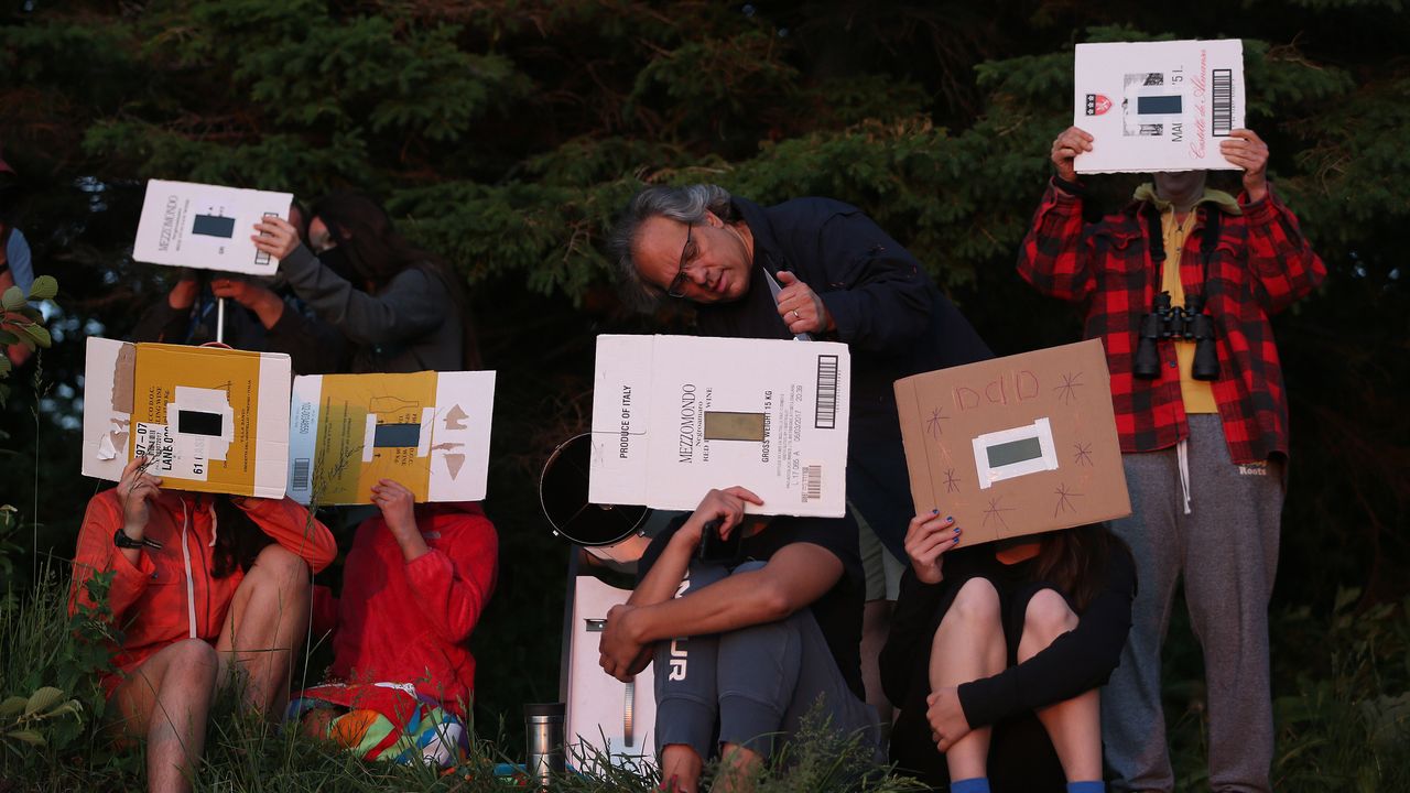 Skywatchers in Toronto use homemade eclipse viewers to watch the solar eclipse on June 10, 2021.