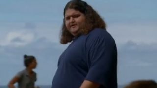 Jorge Garcia as Hurley, wearing a blue shirt with the sky behind him.