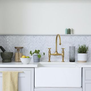 White kitchen counter with sink and bronze tap