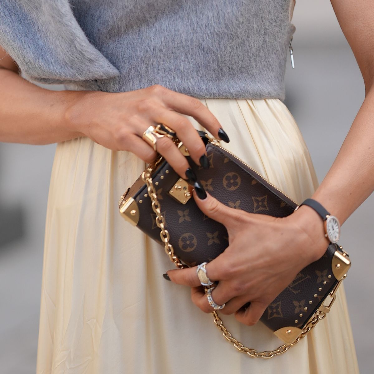 close up of Caro Daur&#039;s hands holding a Louis Vuitton handbag 
