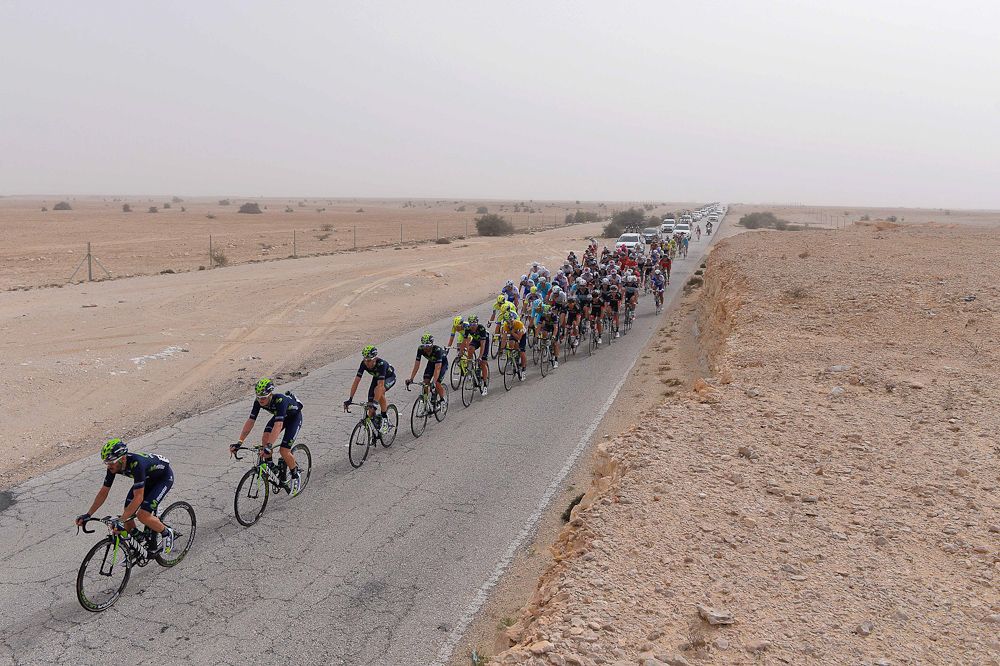 The peloton is lined out in the desert.