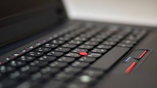 A closeup of the iconic red nubbin in the centre of the ThinkPad X200 laptop's keyboard.