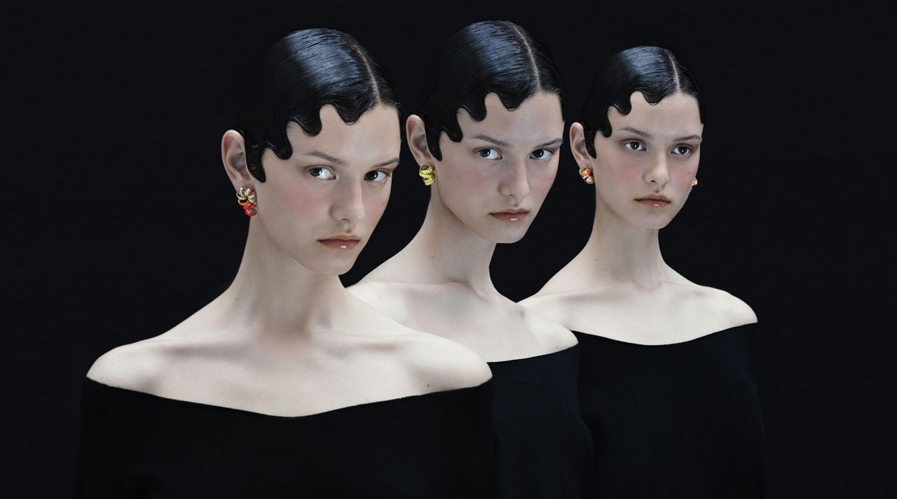 Three women wearing gold-coated brass curly earrings