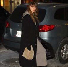 taylor swift in a cashmere dress by the row, boots by the row, and black coat