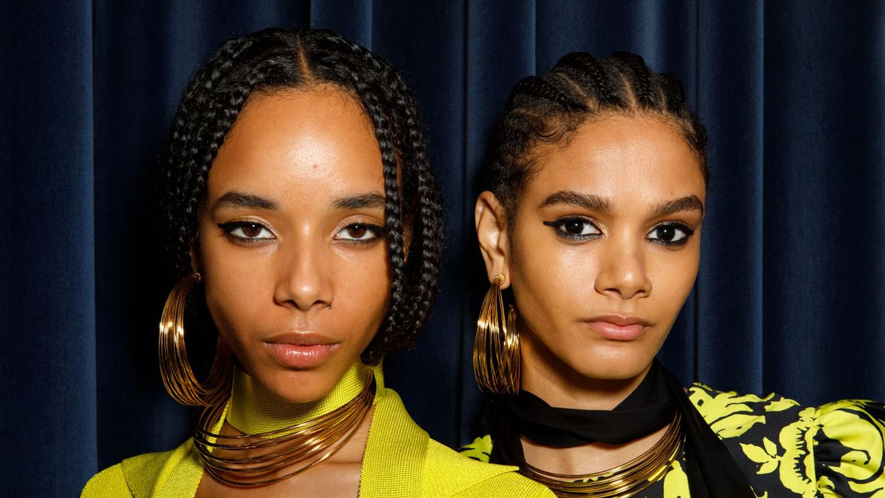 Best cleanser for oily skin - two black models wearing neon and black outfits with gold hoops - getty1699162025