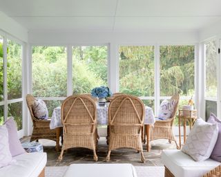 porch with rattan chairs, wooden table with white tablecloth and rattan sofas