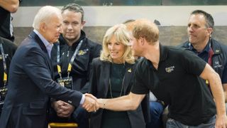 Joe Biden shaking hands with Prince Harry alongside Jill Biden