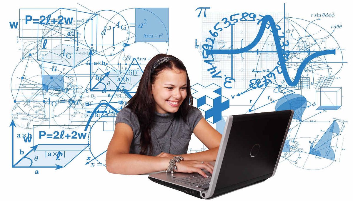 Smiling girl works on laptop computer in front of backdrop of equations and math symbols.