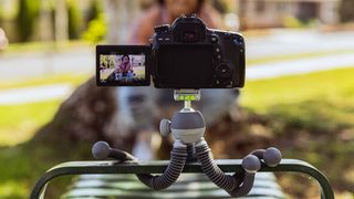 The Joby PodZilla Medium in gray wrapped around a bench