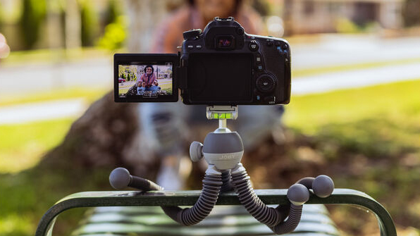 The Joby PodZilla Medium in gray wrapped around a bench