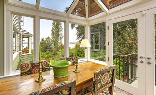 Wooden dining table in sunroom with open patio doors