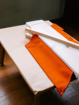 Issey Miyake’s recycled polyester being pressed between two boards of sugi cedar