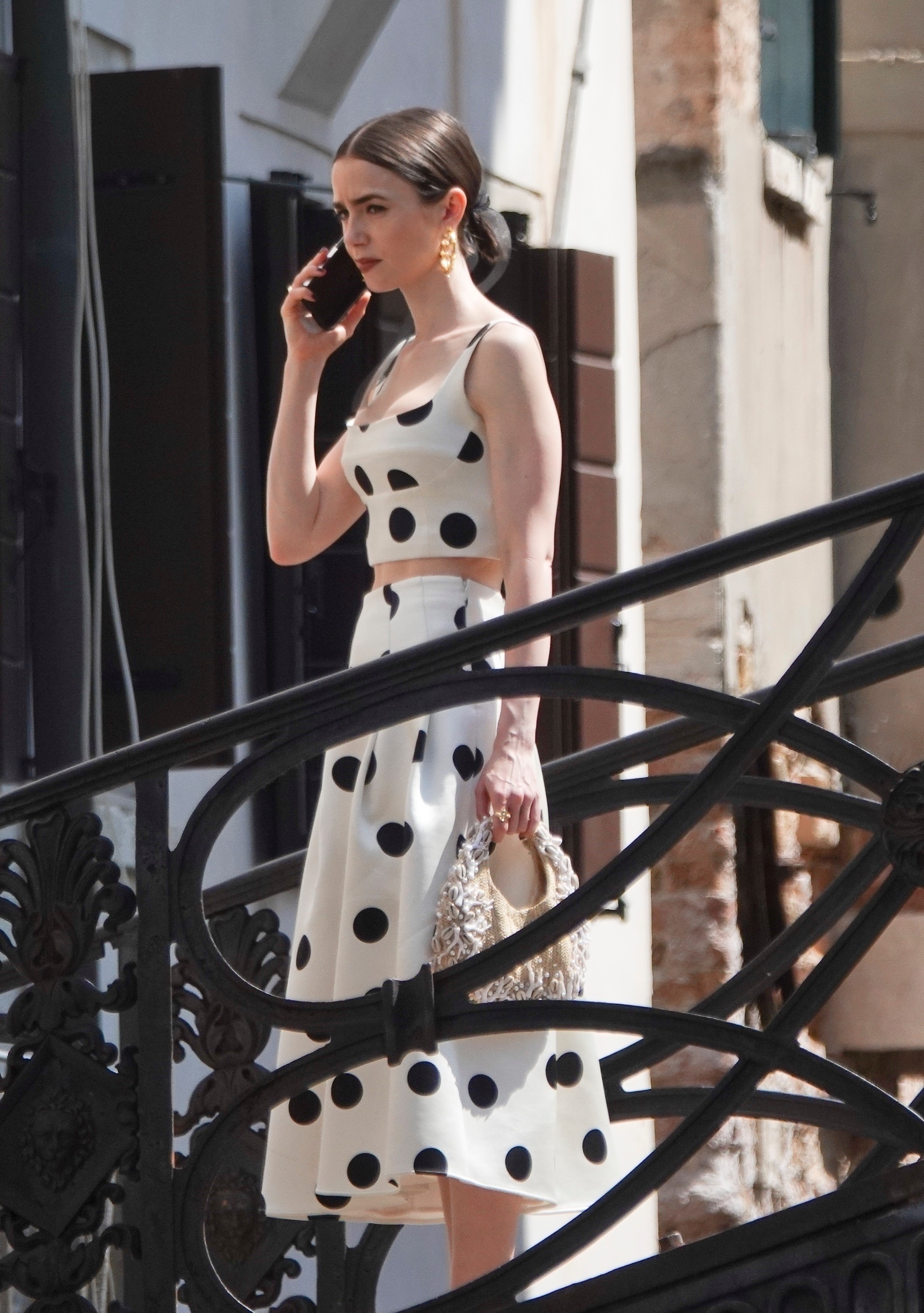 Lily Collins was spotted on the set of Emily In paris wearing polka-dots and a nautical raffia bag