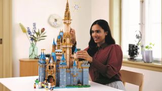 A woman puts the finishing touches to the Lego Disney Castle