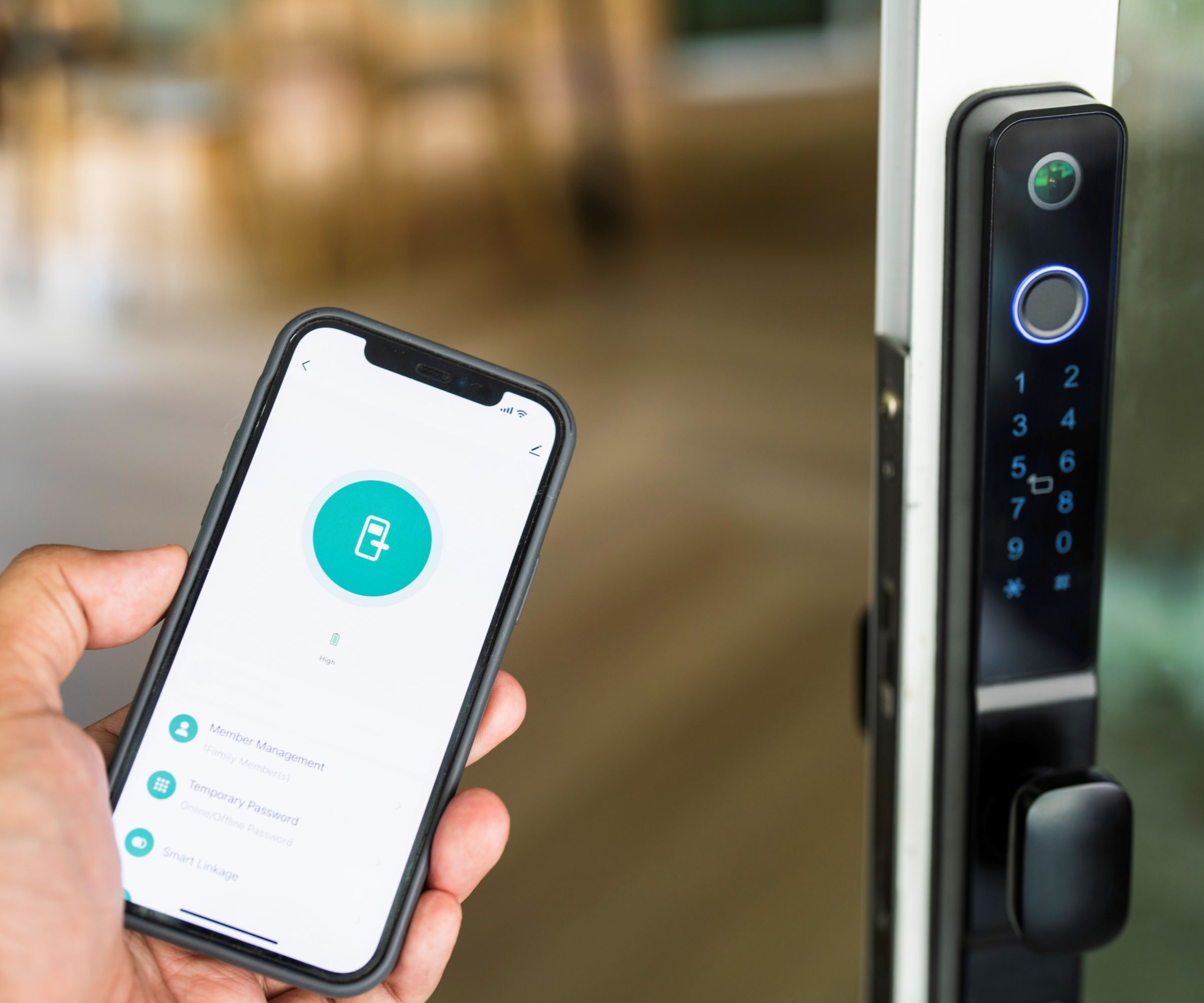 A mobile phone being held in a hand with a large black lock on a door