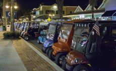 Golf carts parked in a lot.