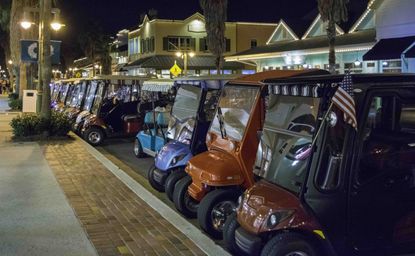 Golf carts parked in a lot.