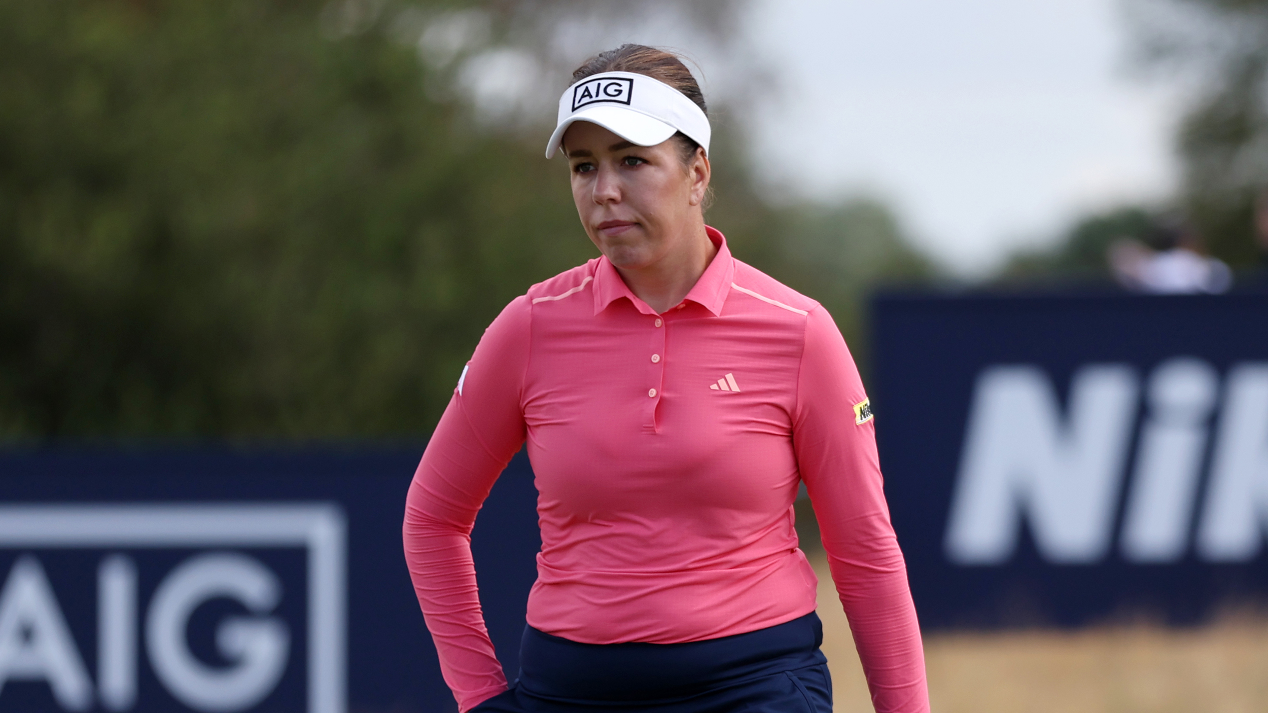 Georgia Hall wearing a pink long-sleeve top and white visor