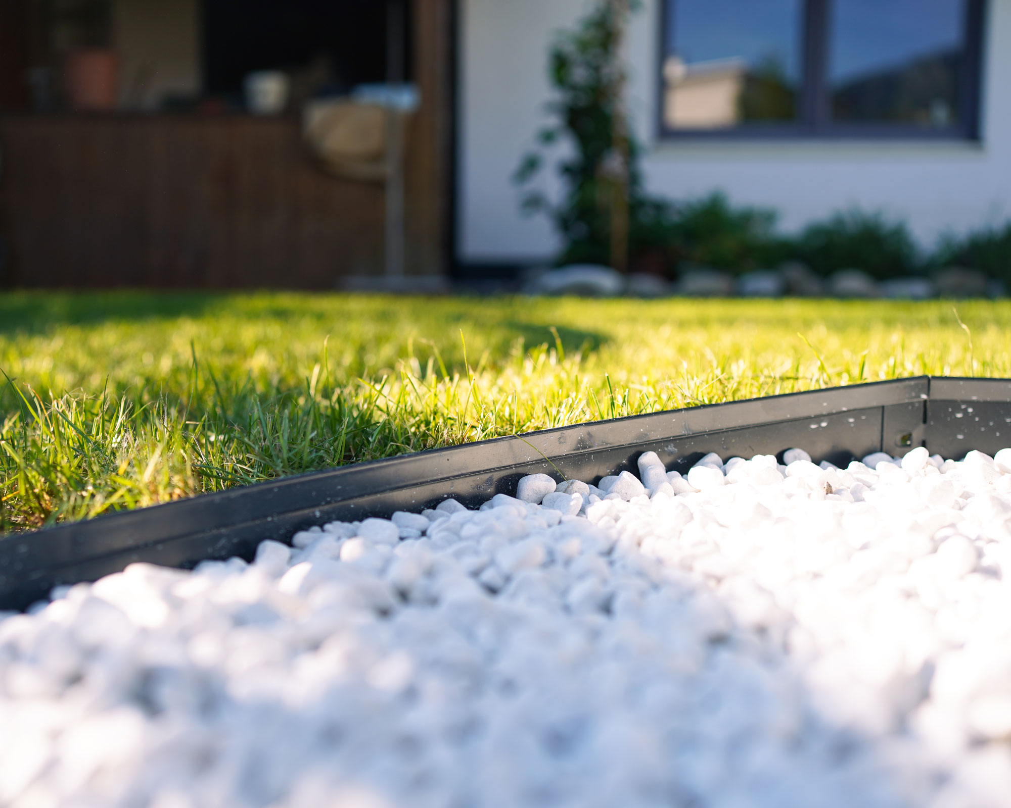 lawn with anthracite metal edging and white pebble landscaping