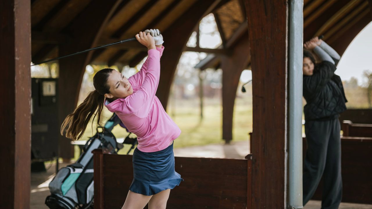 Female golfer practicing at golf range