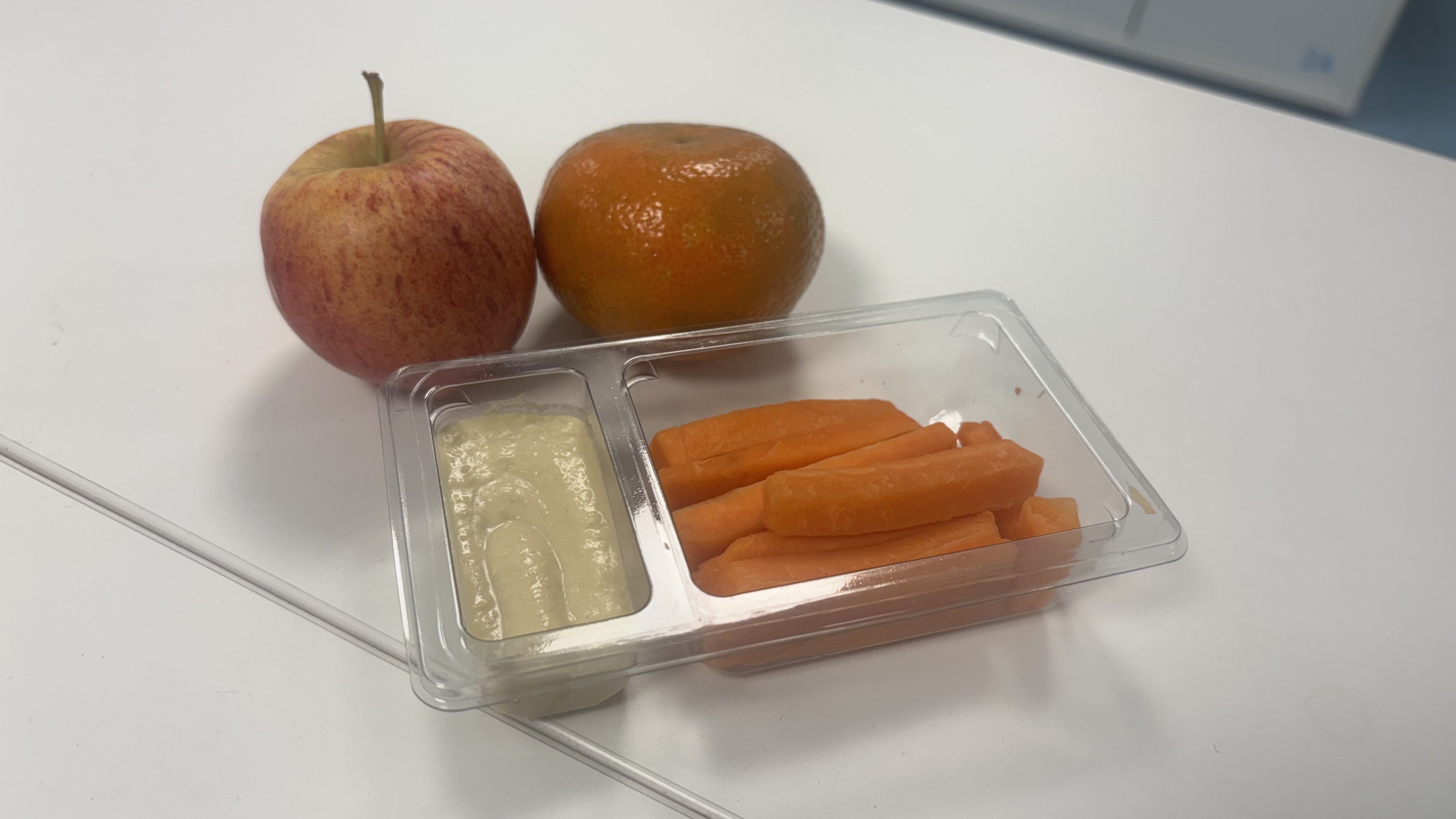 Carrots and hummus, an apple, and a tangerine