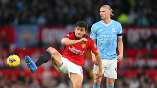  Harry Maguire of Manchester United passes the ball whilst under pressure from Erling Haaland of Manchester City ahead of the 2024 FA Cup final featuring Man City vs Man Utd 