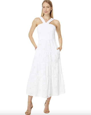 a white lily pulitzer eyelet lace dress in front of a plain backdrop