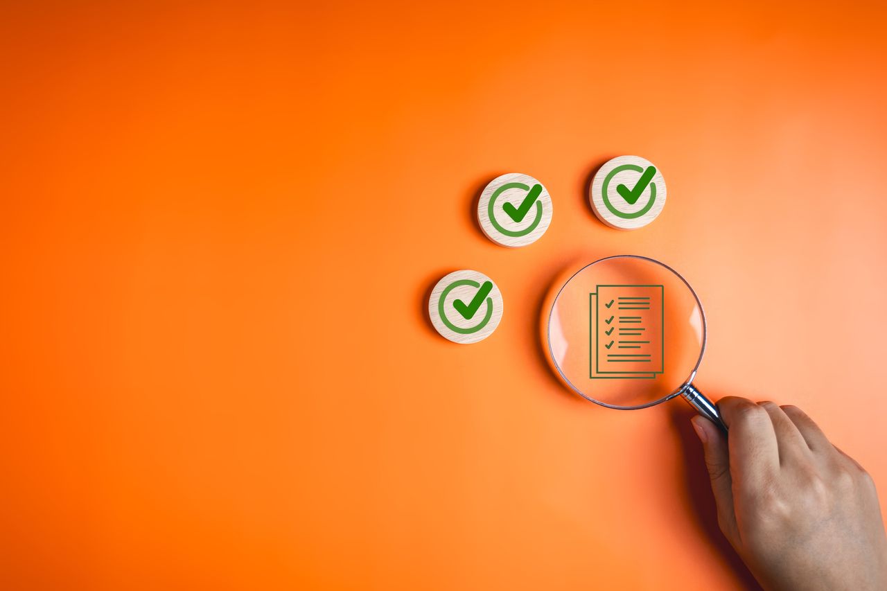 three wooden circles with green checkmarks and a person with a magnifying glass looking at a document