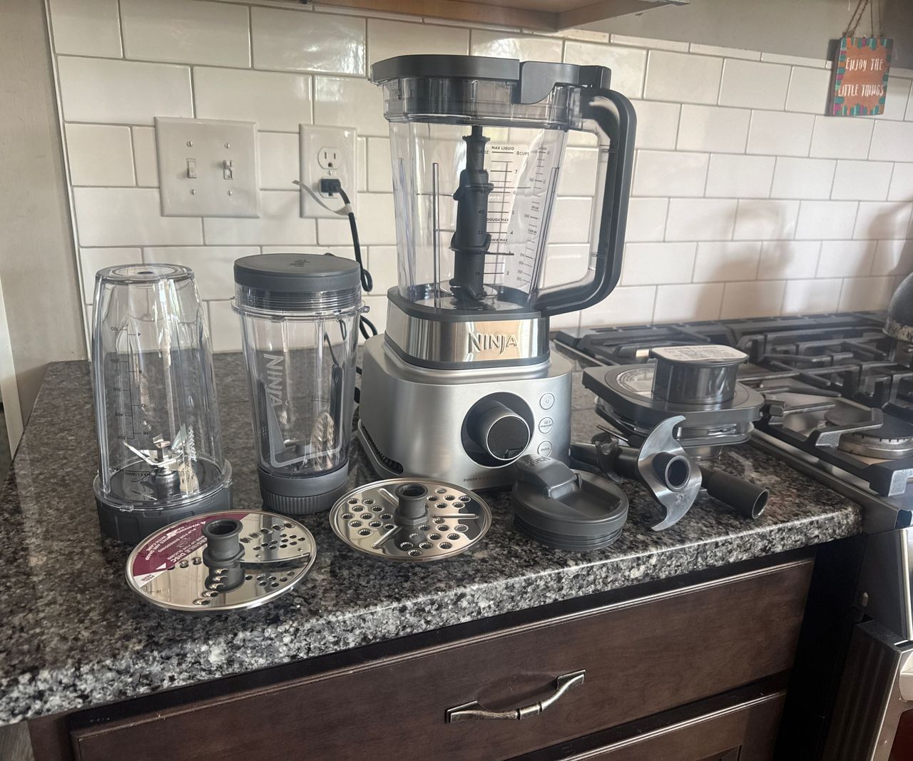 The Ninja Foodi Power Blender Ultimate System on a granite kitchen counter with all the attachments